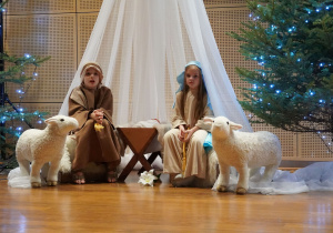 dzieci w roli Józefa i Maryi siedzą w stajence