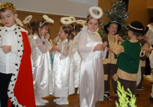 dzieci dzielą się opłatkiem i składają sobie życzenia