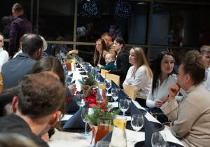 zaproszeni goście siedzą przy stole