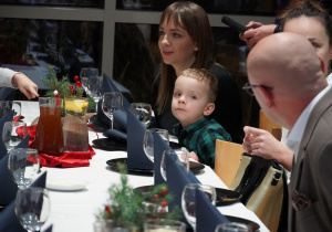 zaproszeni goście siedzą przy stole