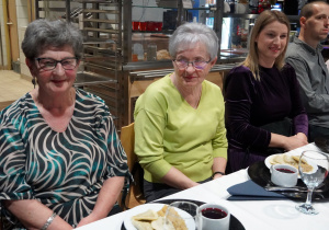 zaproszeni goście siedzą przy stole