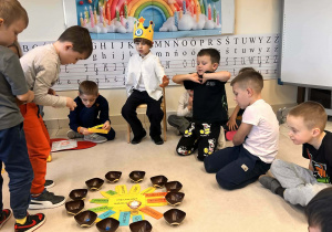 dzieci siedzą na dywanie