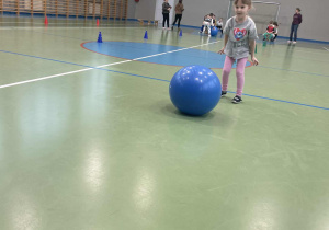 dziwczynka toczy piłkę