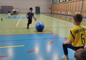 chłopiec toczy piłkę