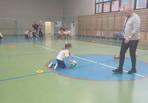 dziewczynka zamienia piłki miejscami