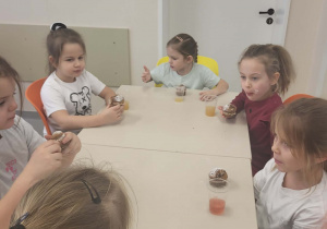 dzieci jedzą babeczki i piją soki