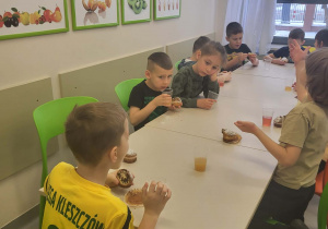 przedszkolaki jedzą babeczki i piją soki