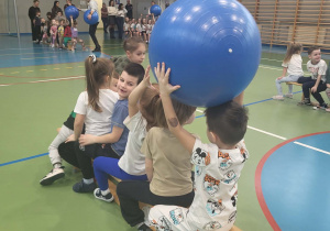 dzieci podają piłkę nad głową