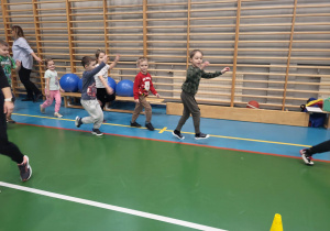 dzieci biegają po sali podczas rozgrzewki