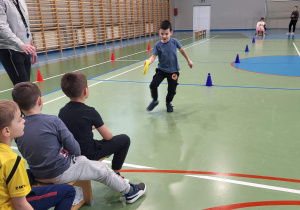 chłopiec biegnie z krążkiem w ręce