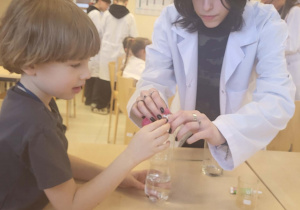 chłopiec i uczenica wykonują doświadczenie chemiczne