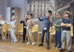 dzieci stoją w półkolu, śpiewając i pokazując piosenke w jęzku angielskim