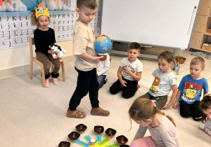 dzieci siedzą na dywanie