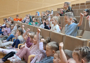 dzieci siedzą na widowni