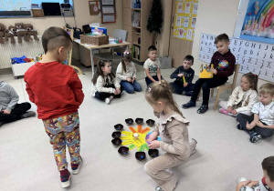 chłopiec trzyma globus a dziewczynka rozkłada koraliki