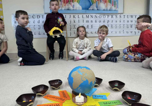 dzieci siedzą na dywanie