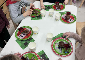 dzieci jedzą babeczki i piją soki