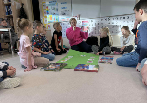 dzieci siedzą w kole z pania i słuchaja informacji i tradycji świąt Bożegonarodzenia w Wielkiej Brytani