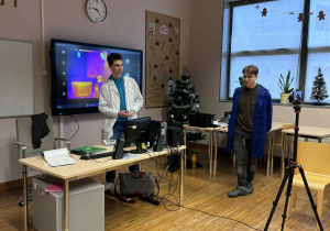 uczeń technikum i nauczycielka od fizyki stoją i opowiadają co będzie tematem zajęć