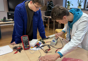 uczniowe technikum podłaczają sprzęt do wykonania eksperymentu