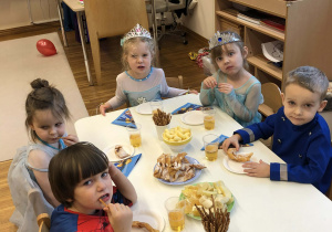 dzieci siedzą przy stolikach