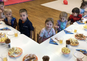 dzieci siedzą przy stolikach