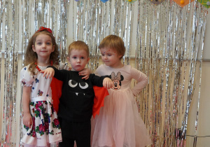 dzieci w swoich strojach pozują na ściance