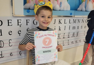 Chłopiec pozuje z dyplomem