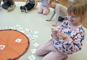 dziecko kładzie na pizzy składniki