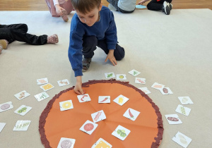 dziecko kładzie na pizzy składniki