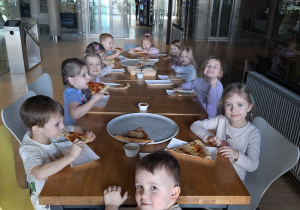 dzieci jedzą pizzę