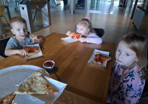 dzieci jedzą pizzę