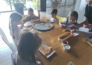 dzieci jedzą pizzę