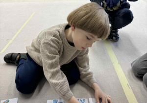chłopiec dopasowuje ilość ubrań do odpowiedniej liczby