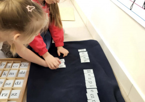 dziewczynki układają z liter alfabetu napis dzień Bezpiecznego Internetu