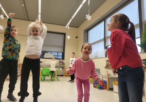 dzieci skaczą do góry w zabawie odgrywając scenkę