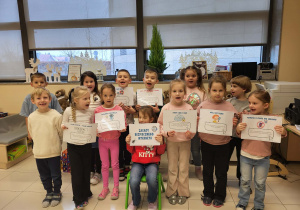 dzieci trzymają plansze z zasadami bezpiecznego internetu