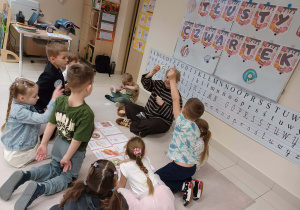 dzieci siedza w kole, pani pokazuje mały obrazek pączka, który musza dopasować do dużego obrazka