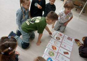 dzieci wykonują zadanie polegające na podpisywaniu w języku angielskim smaków pączków
