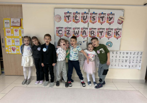 dzieci pozują do zdjęcia na tle napisu "Tłusty Czwartek"