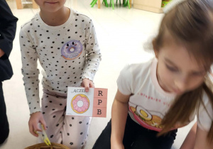 dziewczynka trzyma obrazek i klamerkę