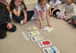 dzieci siedzą w kole i układają składniki na zrobienie pączka