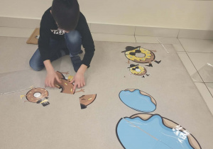 chłopiec ukada z rozsypanki pączki