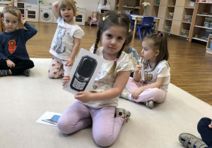 dziewczynka pokazuje obrazek z telefonem