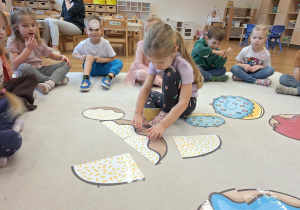 dziecko układa puzzle pączki