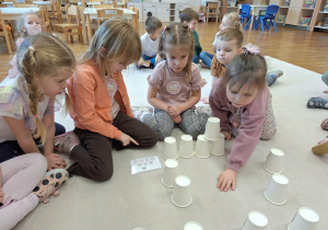 dzieci układają wieżę z kubeczków