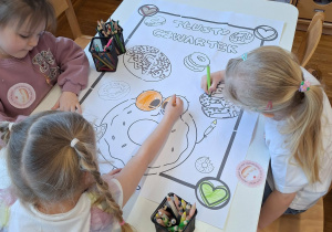 dzieci kolorują kolorowankę