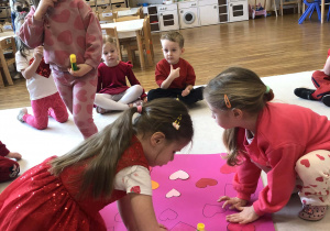 dzieci przykleją serca na karton