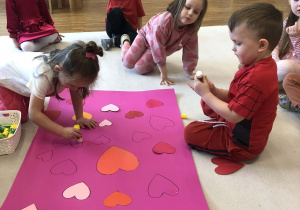 dzieci przykleją serca na karton