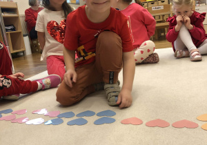 chłopiec układa serca